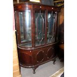 A George V mahogany breakfront bookcase, the upper section with curved glass sides,