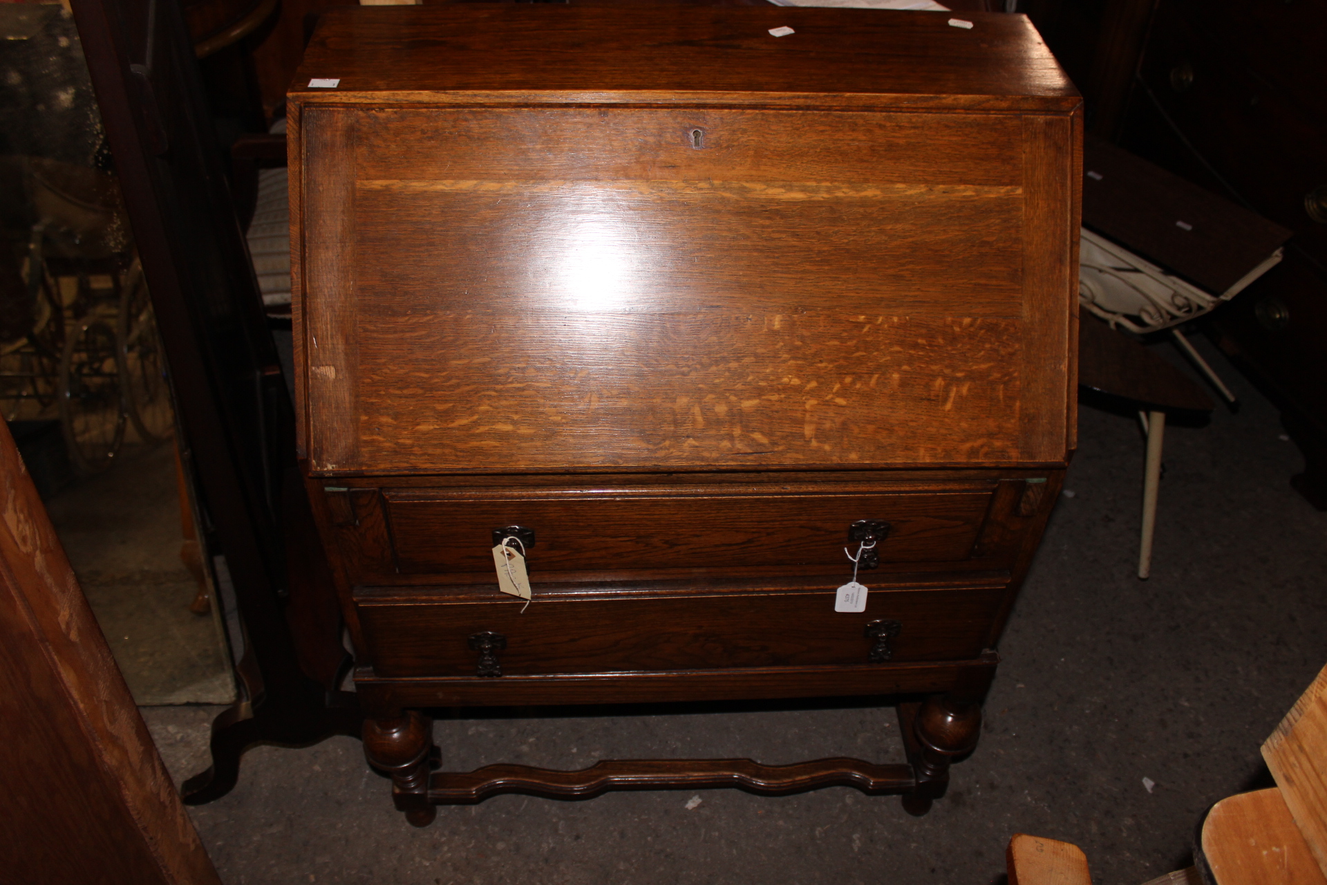 A George V oak bureau, the fall enclosing a fitted interior,