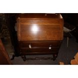 A George V oak bureau, the fall enclosing a fitted interior,