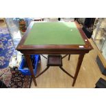 An Edwardian string mahogany games table with secret drawer mechanism