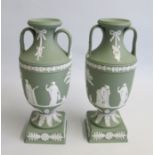 A Pair of 20th Century Wedgwood Green Jasper twin handle vases. Mounted on square plinths.