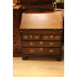 A George II style oak bureau, the fall enclosing a fitted interior, well below, drawers to base