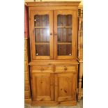 A contemporary pine side cabinet, the upper section with two glazed doors,