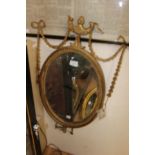 A late 19th Century gilt gesso oval wall mirror,