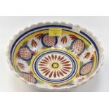 A mid to late 19th Century Quimper bowl with geometric and petal designs, and scalloped rim, 23.