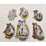 Six late 19th Century and 20th Century Quimper bag pipe wall pockets, brightly decorated,