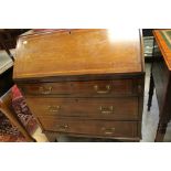 An Edwardian mahogany bureau three drawer with brass swing handles