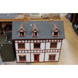 A large dolls house with fitted interior and multiple items of furniture etc
