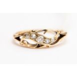 An Edwardian diamond set ring, open work scroll detail set with five graduated diamonds,