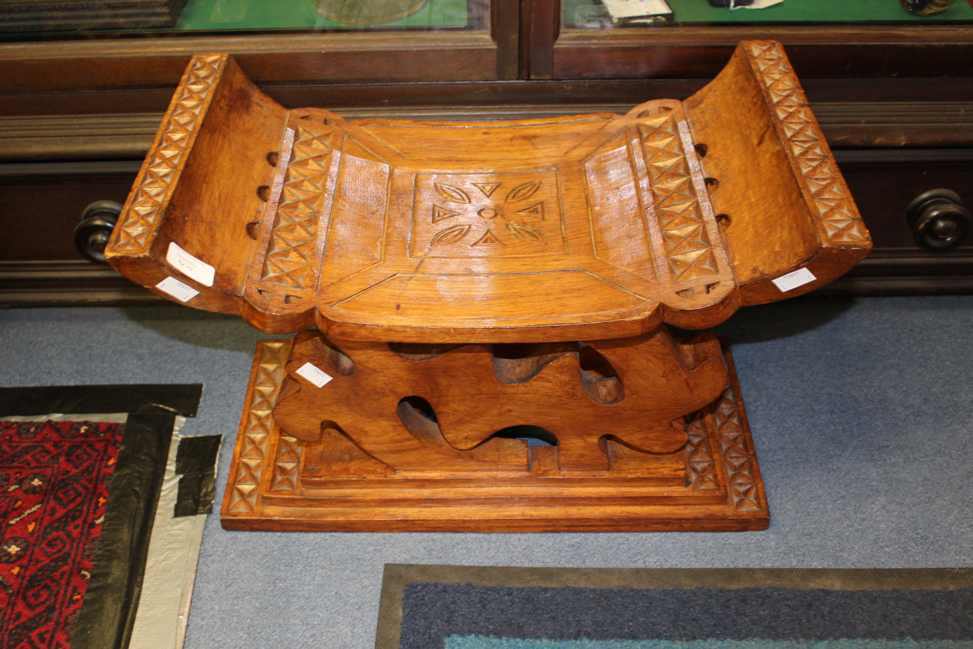 A Ghanian hardwood prayer stool, hand carved throughout,