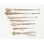Six silver handled button hooks and a shoe horn