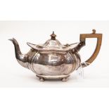 A Continental probably silver teapot, shaped oval with wavy rim on four ball feet,