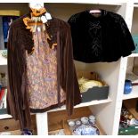 A brown velvet Edwardian cape with a paisley lining and a ruffled neckline;