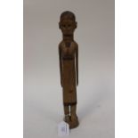 An East African 19th Century carving of a lady with corn row hair style and wearing a skirt,