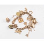 A 9 ct yellow gold charm bracelet with numerous charms (champagne/wine bucket charm detached) total