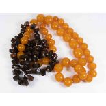 A rough cut dark amber heat treated necklace along with a reconstituted amber coloured bead