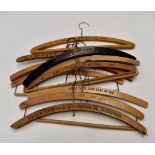 A collection of ten wooden advertising coat hangers,