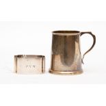 A George V silver miniature mug, London 1911, with inscribed initials, together with a napkin ring,