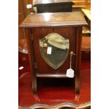 An Edwardian mahogany freestanding mirrored table top cabinet, fitted with a single mirrored door,