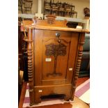 A light oak bedside purdonium with a carved front.