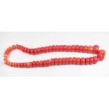 An early 20th Century string of dyed coral graduated beads