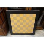 A mid 20th Century chequer topped games table, raised on folding legs,