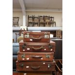 A collection of Four vintage tan suitcases