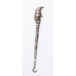 A silver punch button hook,
