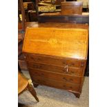 An Edwardian oak and parquetry inlaid bureau, the fall front enclosing a fitted interior,