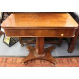 An early 19th Century mahogany fold-over tea table, raised on an octagonal column,