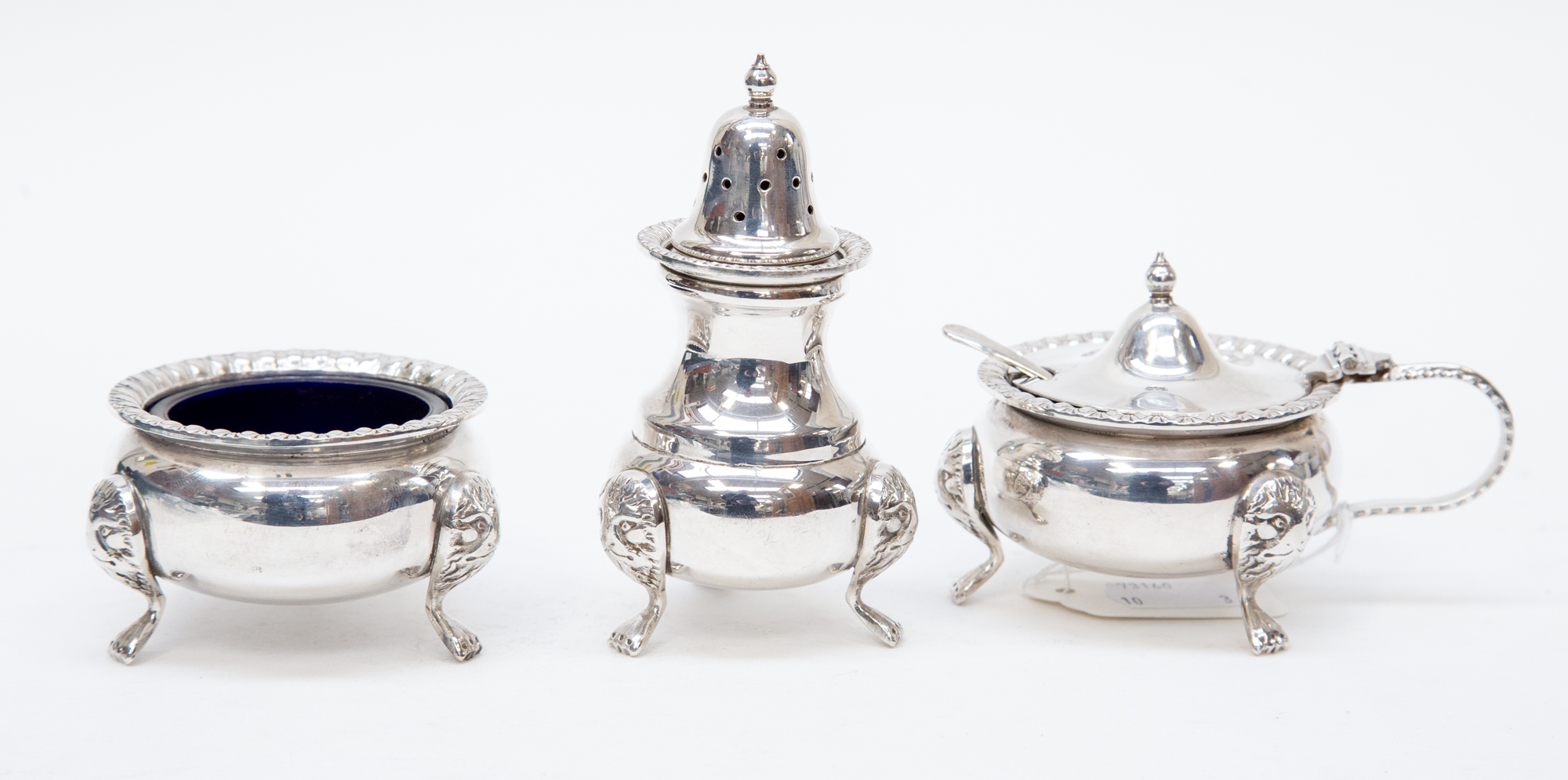 A three piece EPNS glass lined cruet set with spoon (3)