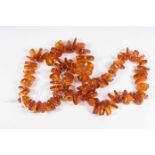A mid 20th Century amber single strand necklace, with various sized irregular beads,