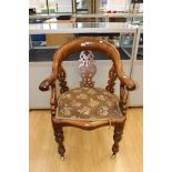 A Victorian parlour arm chair, beech frame, porcelain castors, carved fretwork, upholstered back,