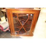 A George III mahogany hanging corner cabinet, fitted with a single glazed door,