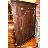 Two oak corner cupboards with brass hinges,