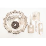 A collection of silver including an Edwardian three piece dressing table set,