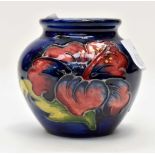 A small Moorcroft Hibiscus pattern baluster vase, with rich blue ground,