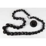 A Jet bead necklace comprising faceted round graduated beads, largest bead approx 20mm,