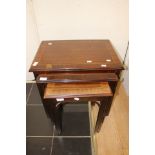 A reproduction mahogany nest of three tables.