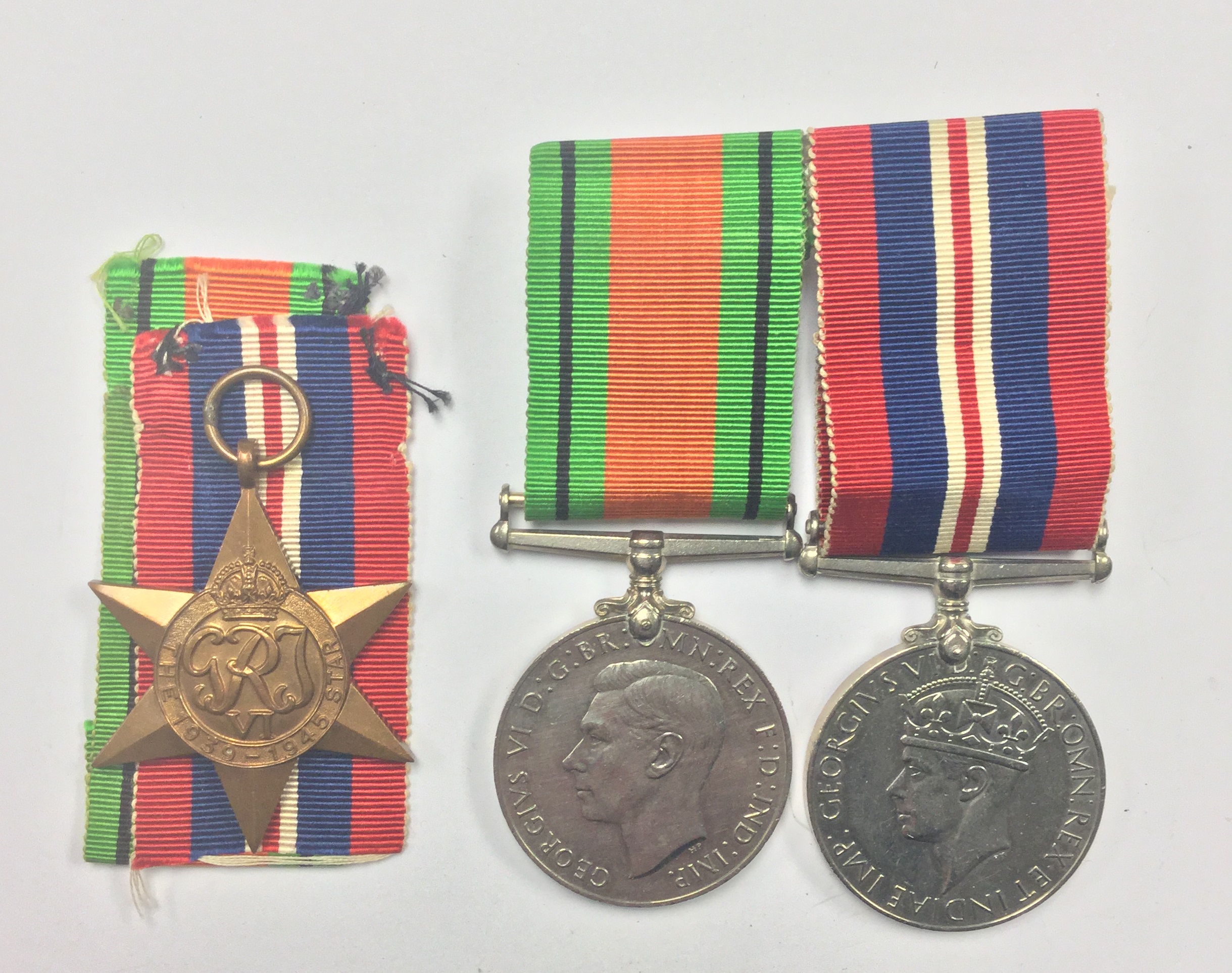 WW2 British 1939-45 Star, no ribbon, and a pair of mounted War and Defence medals.