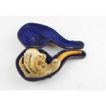 A cased meerschaum pipe, carved as a birds claw clasping the bowl with deer, mountain goat and