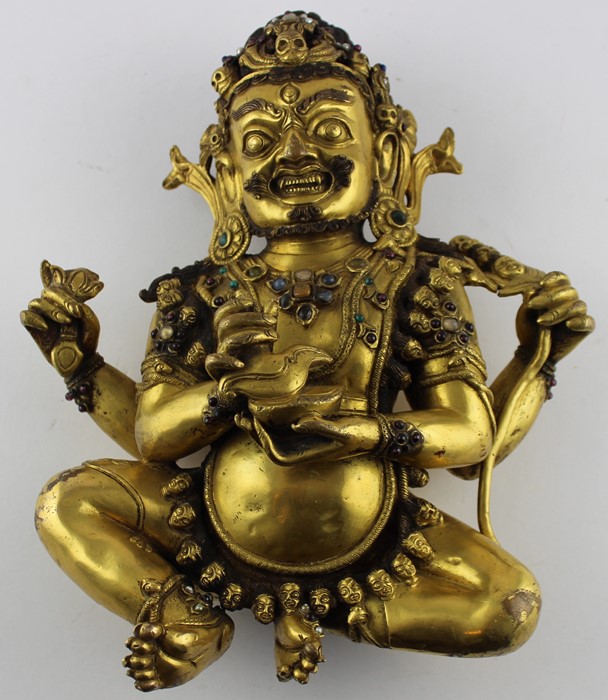 An early 20th century Sino-Tibetan gilt bronze of a seated Mahakala, the wrathful Diety having a