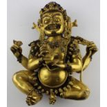 An early 20th century Sino-Tibetan gilt bronze of a seated Mahakala, the wrathful Diety having a