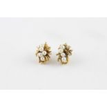A pair of yellow metal and pearl earrings, the raised openwork mount with textured and curved yellow