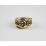 An Italian 18ct. yellow gold and sapphire ring, the wire work ring set row of seven graduated