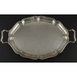 A silver twin handled oval tray, assayed Birmingham 1933, makers mark rubbed, having stepped