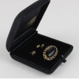 A 9ct yellow gold and onyx oval brooch and earrings en suite, the brooch set central oval cabochon