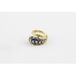 An yellow metal and enamel ring, fashioned as a stylised snake with raised filigree work and