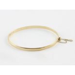 A 9ct. yellow gold bangle, hallmarked for 9 carat gold, height 4mm x maximum diameter 6.5cm. (7.9g)