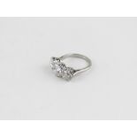 A platinum and three stone diamond ring, having round brilliant cut centre stone (weight approx. 2.0
